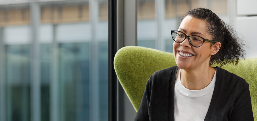 Karen egy zöld székben ül, és mosolyog.