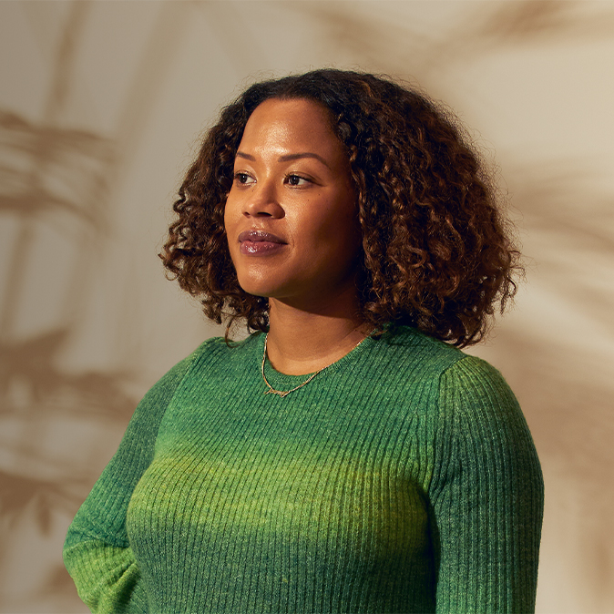 Sydney 站在室內，自信地看向她的右側。