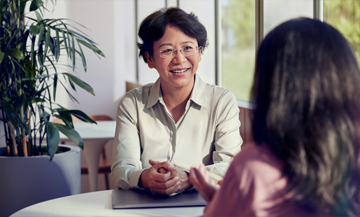 Jean sitzt neben einem Kollegen am Tisch.