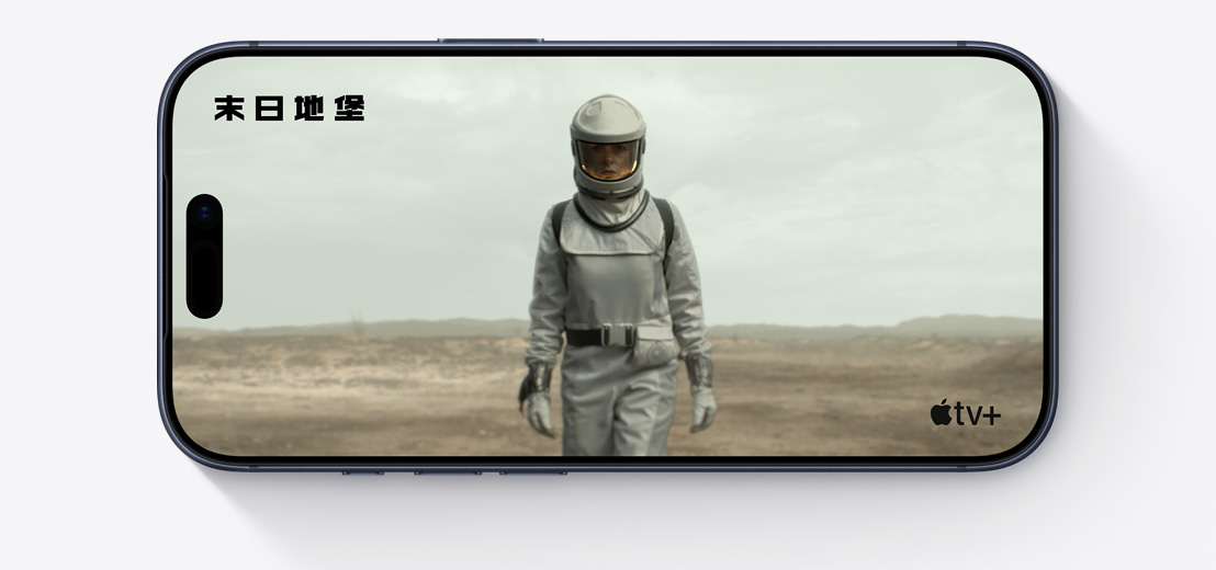 橫放的 iPhone 機身正面，展示 Apple TV+ 影集《末日地堡》的剪輯片段，畫面中的人身穿太空服